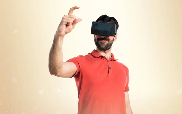 Bonito homem usando VR glassesa e segurando algo — Fotografia de Stock