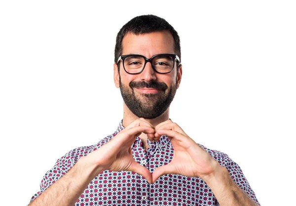 Homem com óculos fazendo um coração com as mãos — Fotografia de Stock