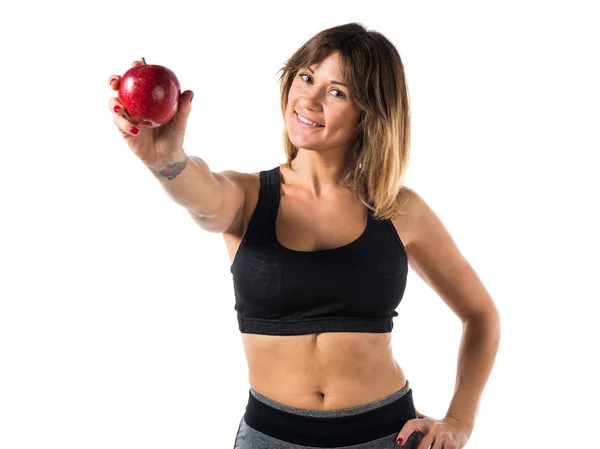 Спортивна жінка, що показує яблуко — стокове фото