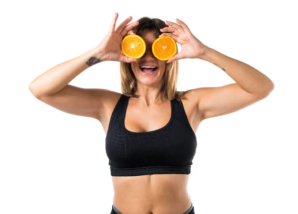 Sport femme portant des tranches d'orange comme lunettes — Photo