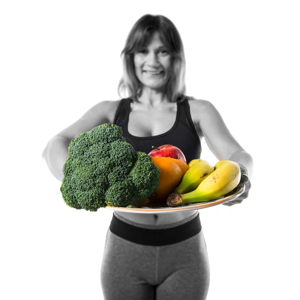 Спортивна жінка тримає фрукти та овочі — стокове фото