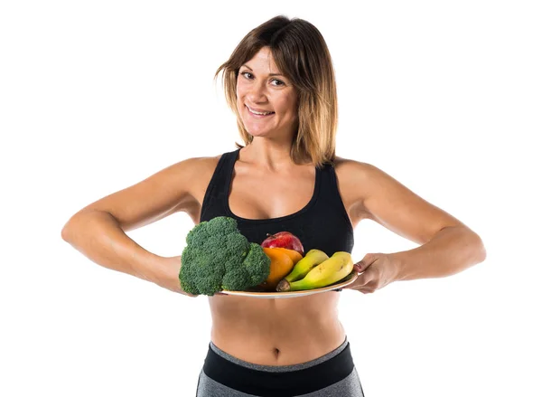 Meyve ve sebze tutan spor kadın — Stok fotoğraf