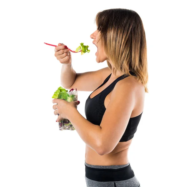 Красивая спортивная женщина ест салат — стоковое фото
