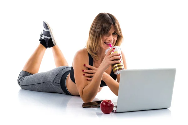 Sport woman working with her laptop and drinking sport drink — Stock Photo, Image