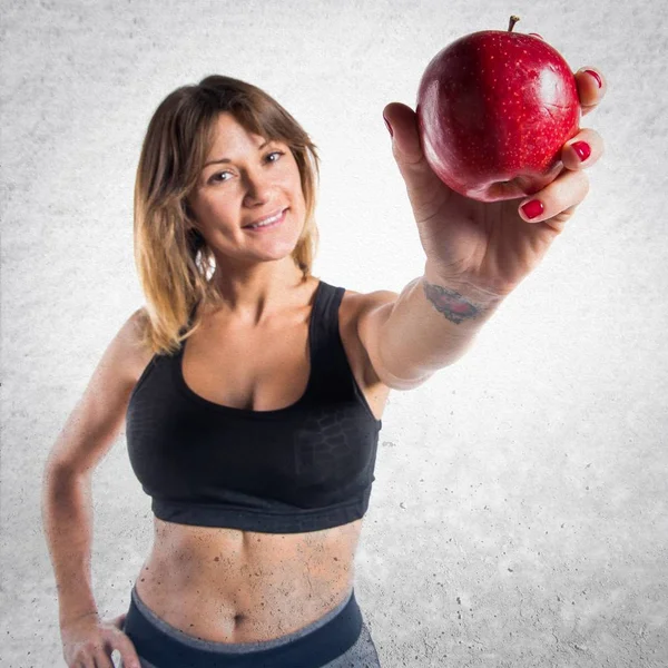 Deportiva mostrando una manzana —  Fotos de Stock