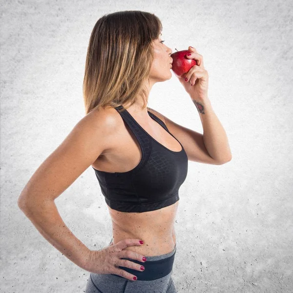 Sportlerin isst einen Apfel — Stockfoto