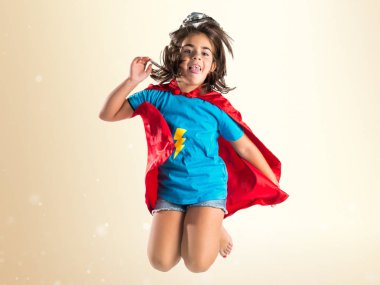 Sevimli küçük kız süper kahraman ve atlama gibi giyinmiş