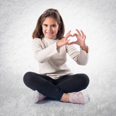 Esmer kız elleri ile bir kalp yapma