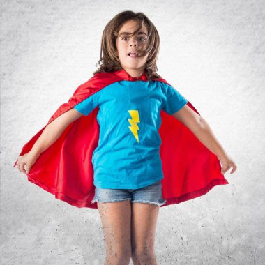 Sevimli küçük kız süper kahraman ve atlama gibi giyinmiş
