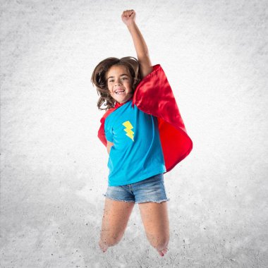 Sevimli küçük kız süper kahraman ve atlama gibi giyinmiş