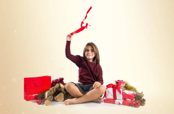 Menina bonito no Natal feriados brincando com uma fita — Fotografia de Stock