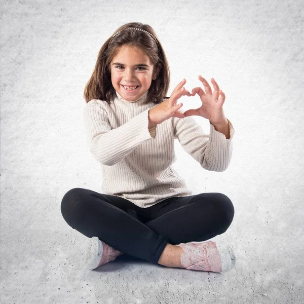 Esmer kız elleri ile bir kalp yapma