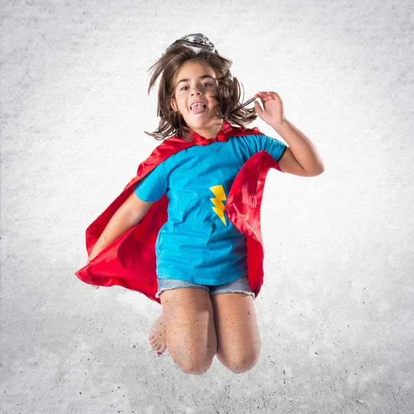 Sevimli küçük kız süper kahraman ve atlama gibi giyinmiş