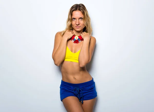 Mulher modelo bonito posando em estúdio com um colar de flores colorido — Fotografia de Stock