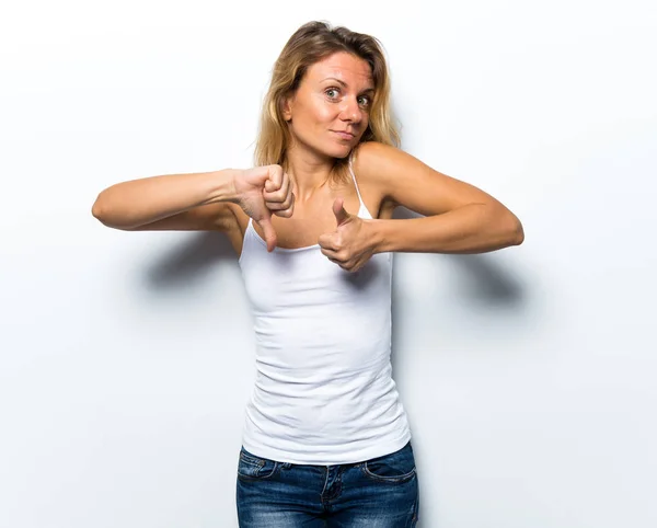 Hübsche junge Frau macht ein gutes-schlechtes Zeichen — Stockfoto