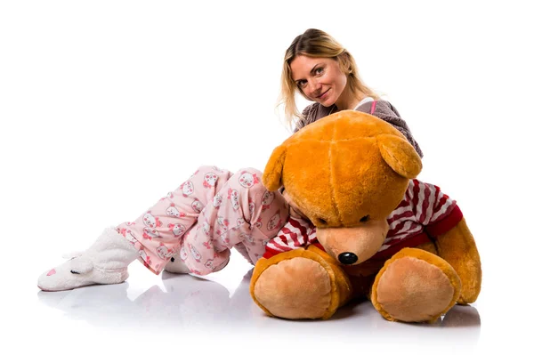 Bella ragazza bionda in pigiama carino con grande animale di peluche — Foto Stock