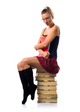 Pek çok kitap üzerinde oturan ve coll tutan güzel sarışın liseli kız