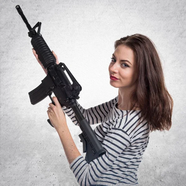 Jovencita bonita sosteniendo una pistola — Foto de Stock