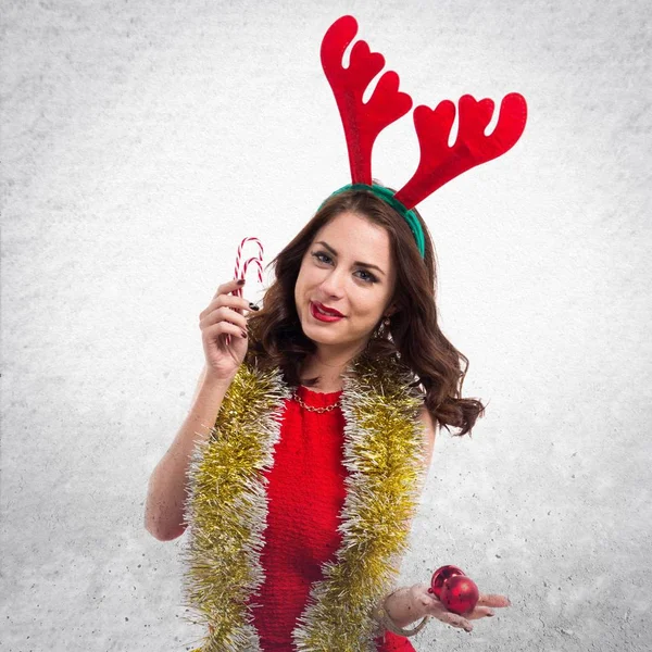Όμορφη νεαρή γυναίκα με κέρατα καραμέλες και τάρανδοι Χριστουγέννων — Φωτογραφία Αρχείου