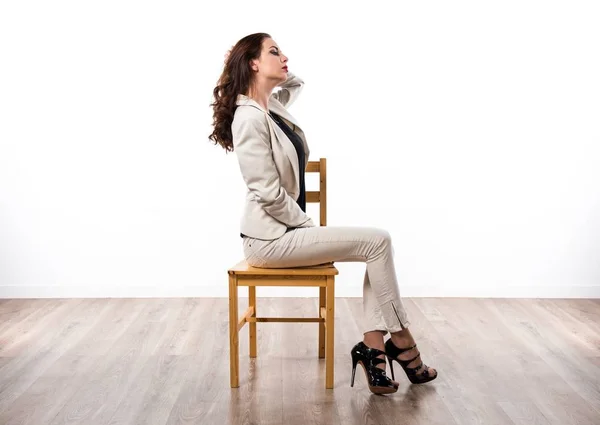 木製の椅子の上に座って美しいブルネットの少女 — ストック写真