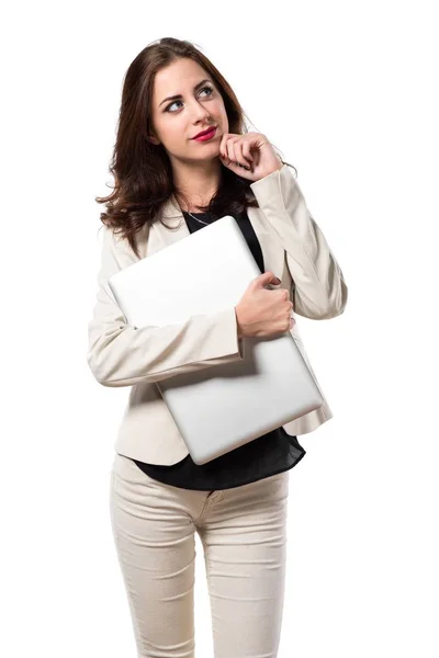 Mooie jonge zakenvrouw met laptop en denken — Stockfoto