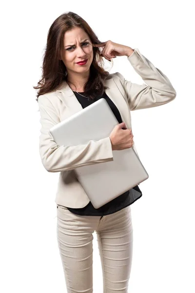 Mooie jonge zakenvrouw met laptop en die betrekking hebben op zijn oren — Stockfoto