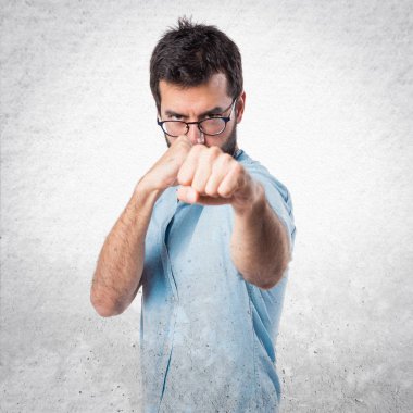 Mavi gözlüklü bir yumruk veren yakışıklı adam