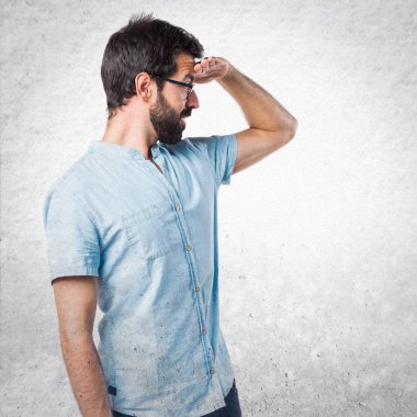 Bir şey gösterilen mavi gözlüklü yakışıklı adam