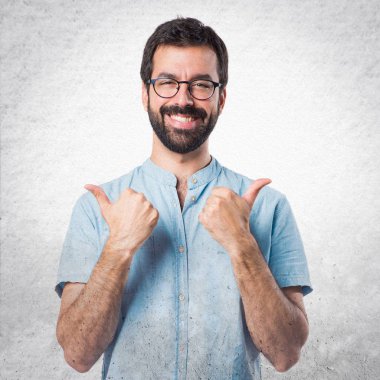 Başparmak ile mavi gözlük ile yakışıklı adam