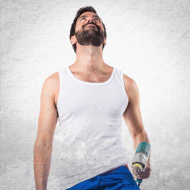 Ararken bir matkap ile genç elektrik teknisyeni