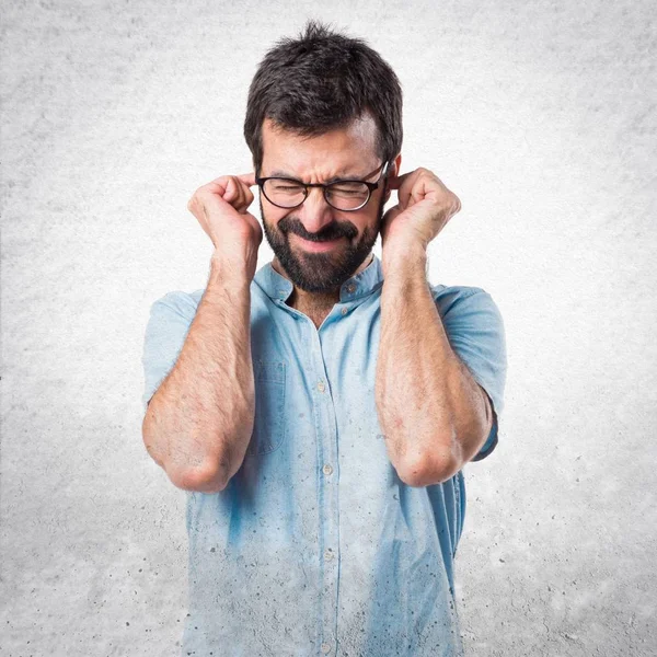 Handsome man covering his ears — Stock Photo, Image