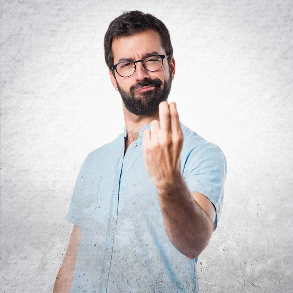 Schöner Mann mit blauer Brille kommt Geste — Stockfoto