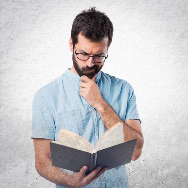 Hombre guapo con gafas azules libro de lectura —  Fotos de Stock