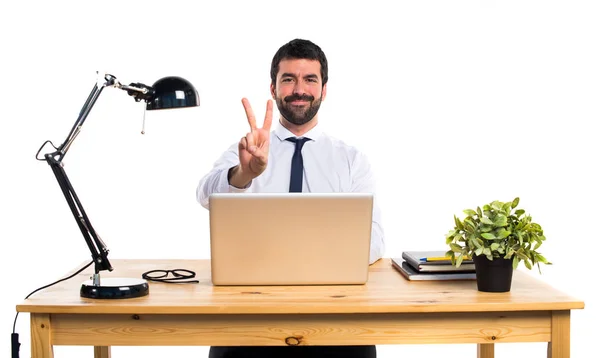 Empresário em seu escritório contando dois — Fotografia de Stock