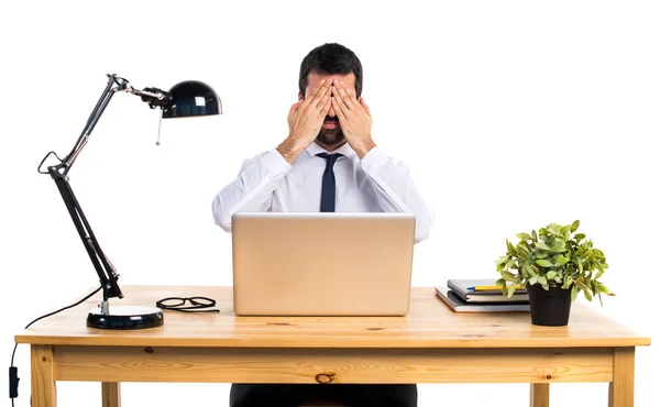 Businessman in his office covering his eyes — Stock Photo, Image