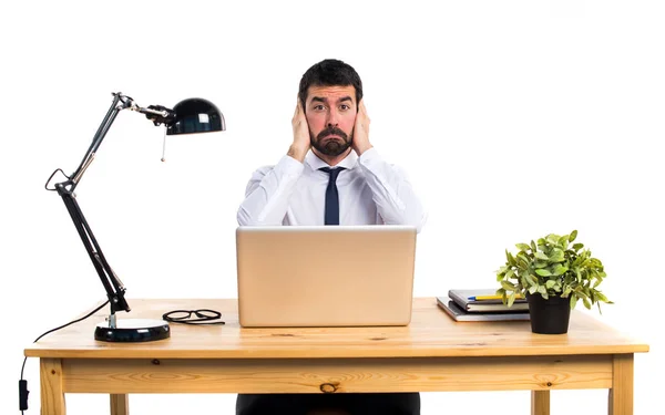Biznesmen w swoim biurze obejmujące jego uszy — Zdjęcie stockowe