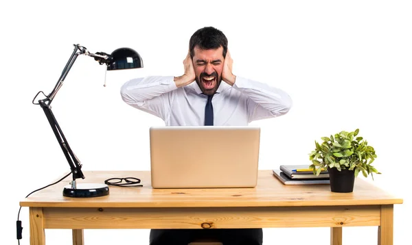 Zakenman in zijn kantoor die betrekking hebben op zijn oren — Stockfoto