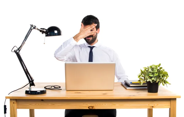 Podnikatel v jeho kanceláři, zakrývaje si tvář — Stock fotografie