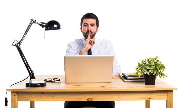 Uomo d'affari nel suo ufficio che fa gesti di silenzio — Foto Stock
