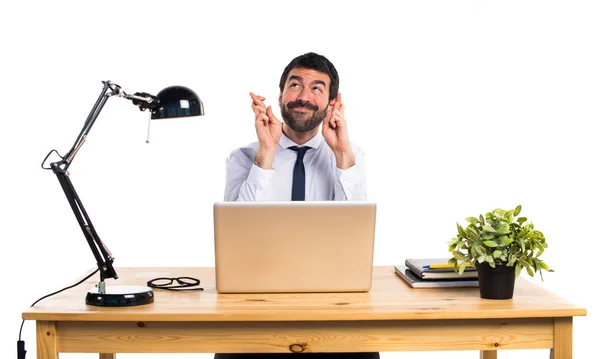 Businessman in his office with his fingers crossing — Stock Photo, Image