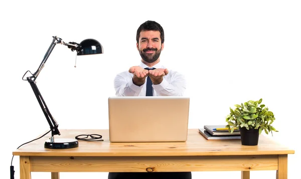 Homme d'affaires dans son bureau tenant quelque chose — Photo