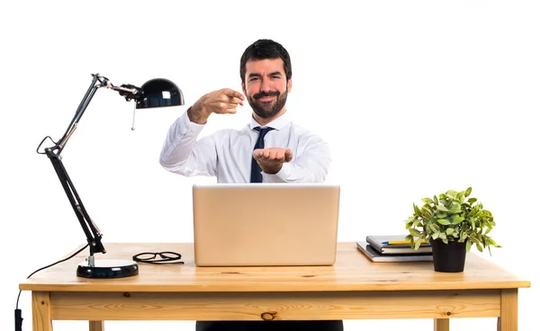 Empresário em seu escritório segurando algo — Fotografia de Stock