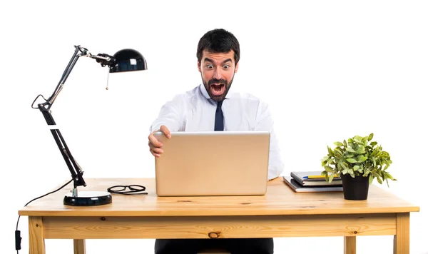 Businessman in his office doing surprise gesture — Stock Photo, Image