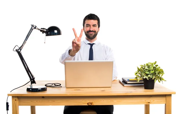 Biznesmen w swoim biurze robi gest zwycięstwa — Zdjęcie stockowe