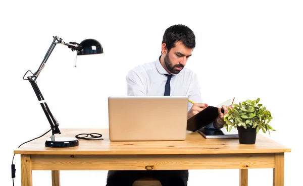 Biznesmen w swoim biurze pisania notatek — Zdjęcie stockowe