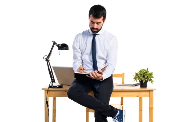 Geschäftsmann in seinem Büro liest Notizen — Stockfoto