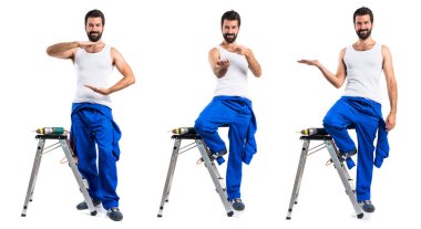 Bir matkap ve bir şey tutan genç elektrik teknisyeni