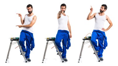 Öne doğru işaret eden bir matkap ile genç elektrik teknisyeni