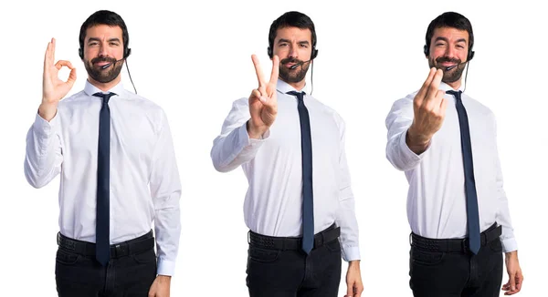 Joven con un auricular contando dos —  Fotos de Stock