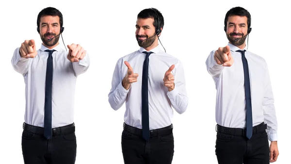 Jonge man met een headset die wijzen op de voorgrond plaatsen — Stockfoto